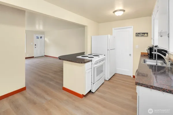 a kitchen with granite countertop a stove a refrigerator and a sink