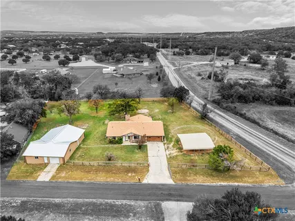 an aerial view of a swimming pool with a yard and lake view