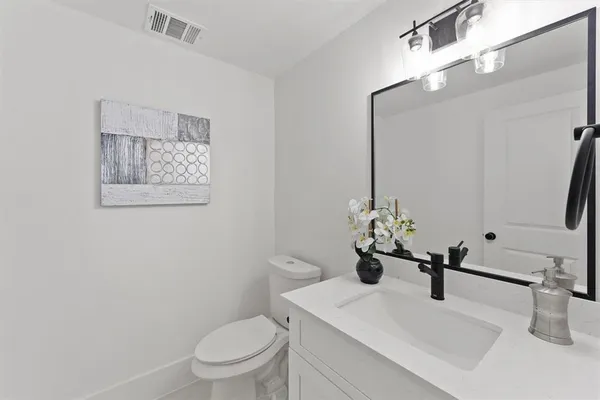 a bathroom with a sink a toilet and mirror