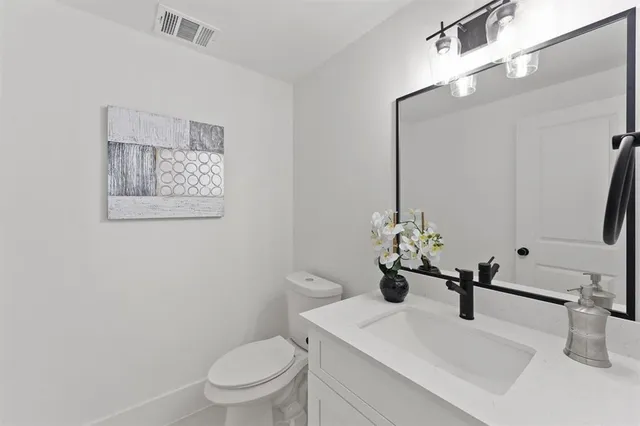 a bathroom with a sink a toilet and mirror