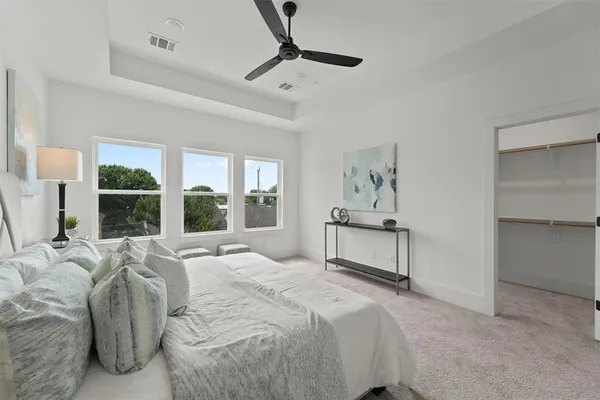 a spacious bedroom with a large bed and a chandelier