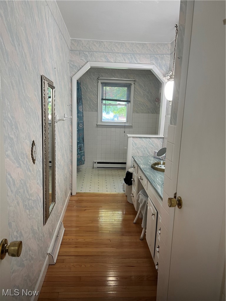 2875 Pinney Topper Road Jefferson, OH 44047 - Photo 19 of 28 Bathroom with vanity, a baseboard radiator, tiled shower, and hardwood / wood-style floors