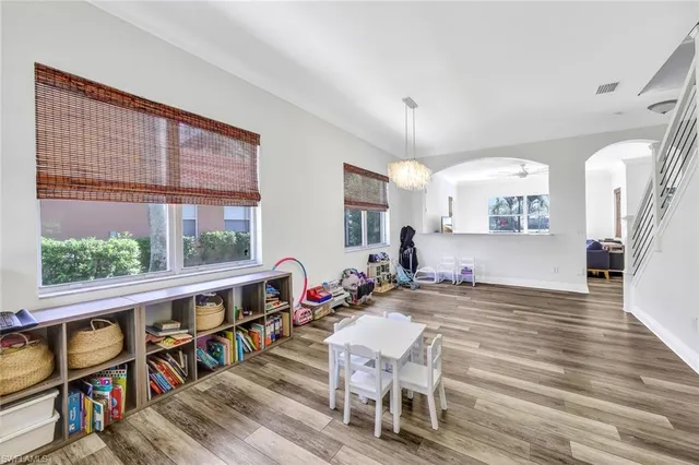 a living room with furniture a rug potted plant and a large window