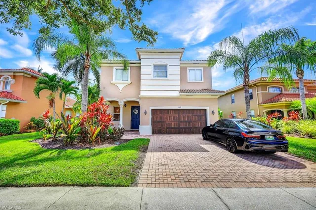 a car parked in front of a house and a small yard