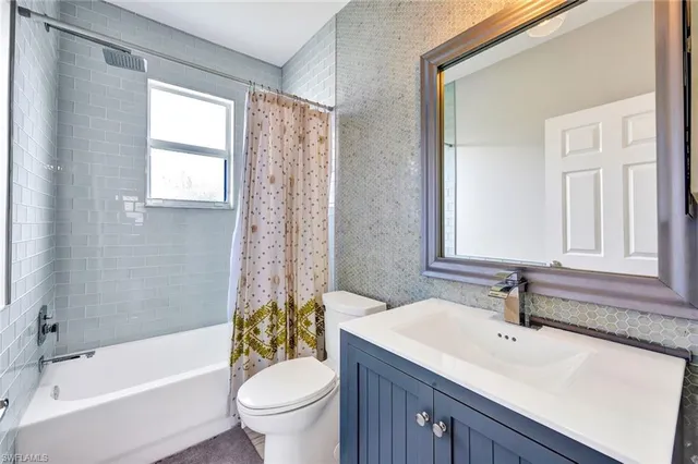 a bathroom with a sink a toilet a window and a mirror