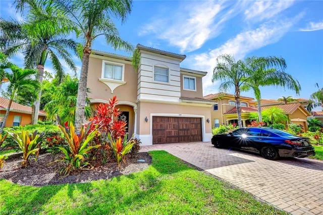 a front view of a house with a yard and potted plants