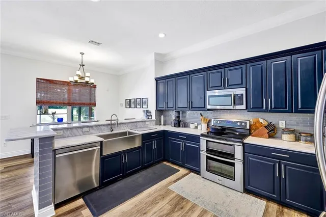 a kitchen with stainless steel appliances granite countertop wooden cabinets stove top oven and sink