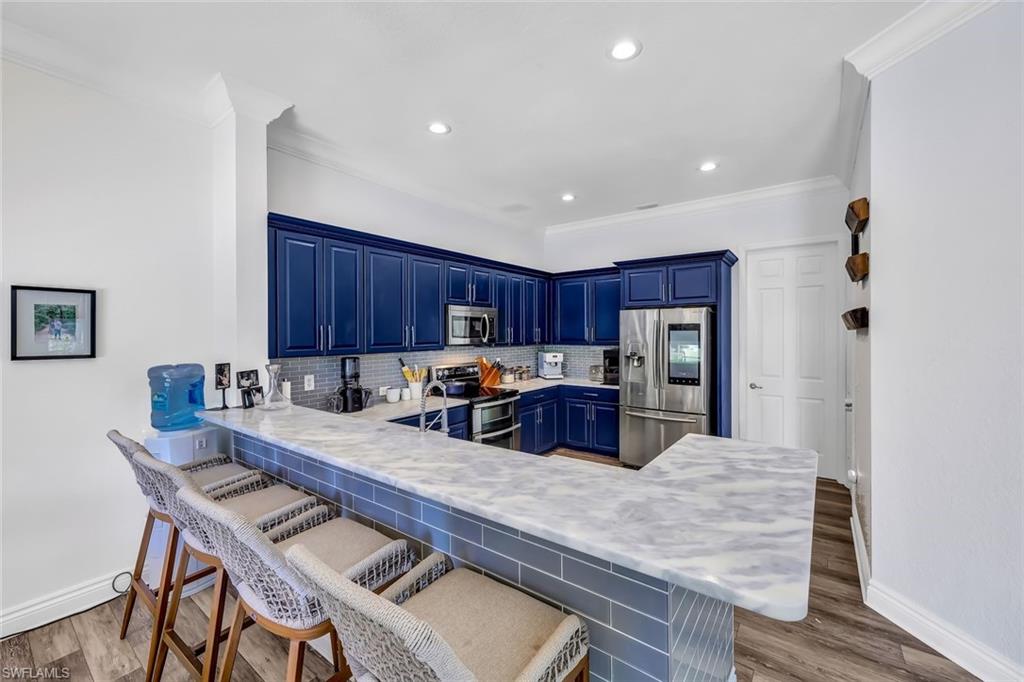 1949 Par Drive Naples, FL 34120 - Photo 7 of 39 a kitchen with a table chairs a refrigerator and a stove