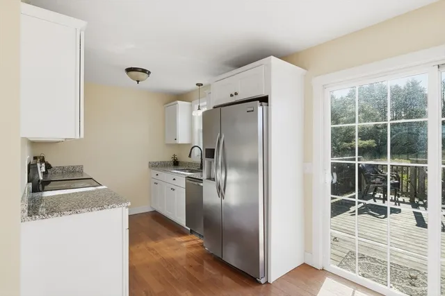 a kitchen with granite countertop a refrigerator and a sink