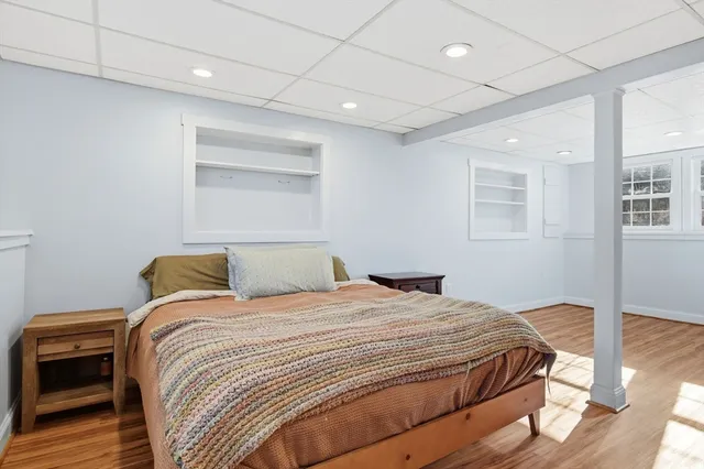 a bedroom with a bed and wooden floor