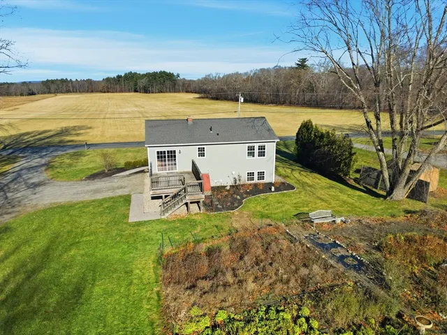 a view of a house with backyard and trees