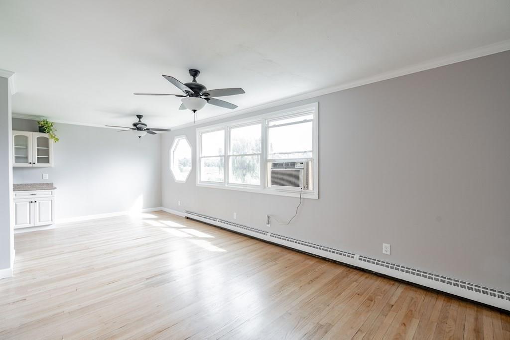 109 New Ludlow Road Granby, MA 01033 - Photo 14 of 42 an empty room with wooden floor chandelier fan and windows