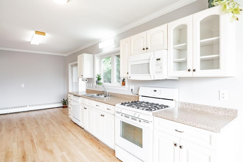 109 New Ludlow Road Granby, MA 01033 - Photo 17 of 42 a kitchen with stainless steel appliances granite countertop a stove a sink and white cabinets with wooden floor