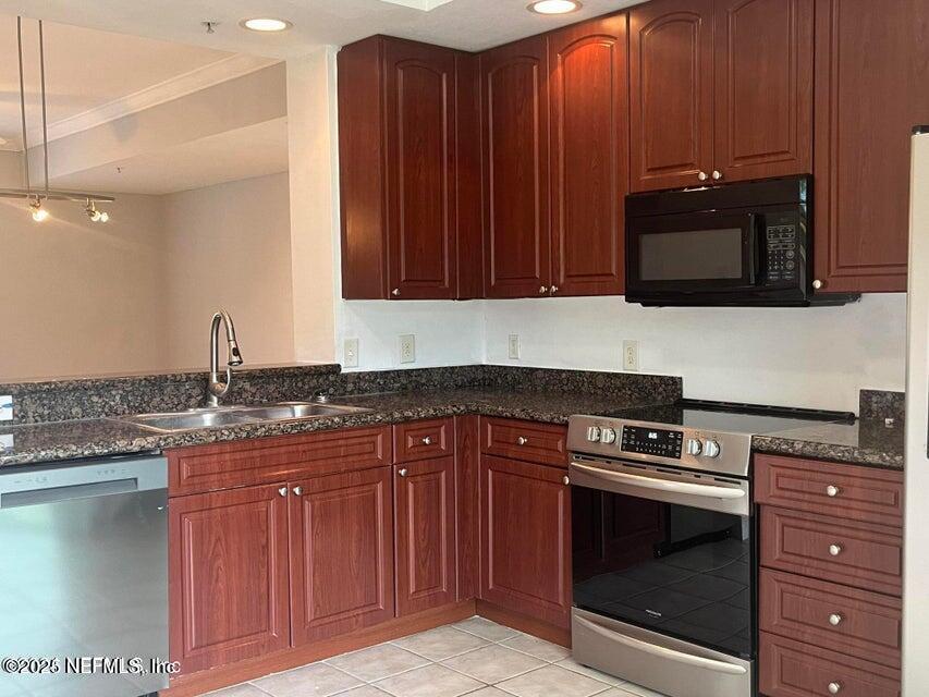 9745 Touchton Road, Unit 1701 Jacksonville, FL 32246 - Photo 9 of 30 a kitchen with granite countertop a stove and a microwave