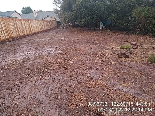 a view of a backyard with wooden fence