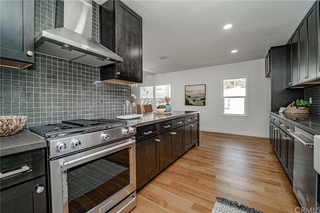 3880 Fairway Boulevard View Park, CA 90043 - Photo 17 of 47 a kitchen with stainless steel appliances granite countertop wooden cabinets stove top oven and sink