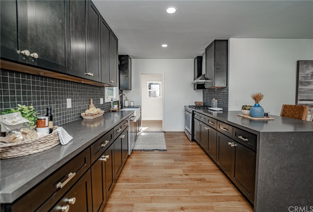3880 Fairway Boulevard View Park, CA 90043 - Photo 18 of 47 a kitchen with stainless steel appliances a sink stove and cabinets