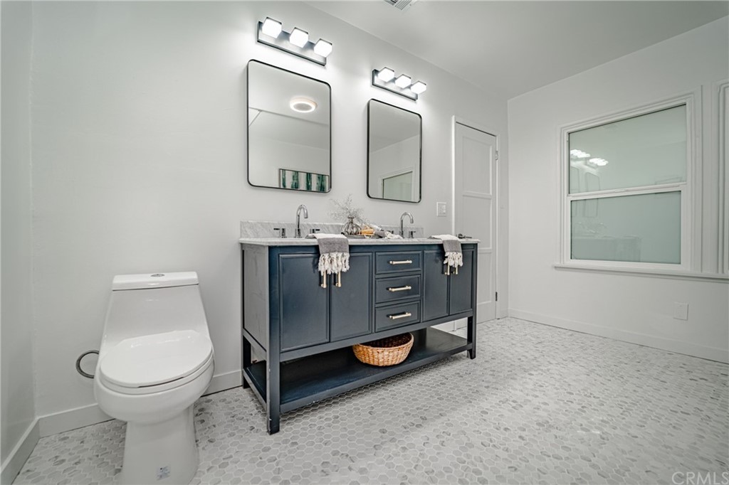 3880 Fairway Boulevard View Park, CA 90043 - Photo 32 of 47 a bathroom with a toilet sink and mirror