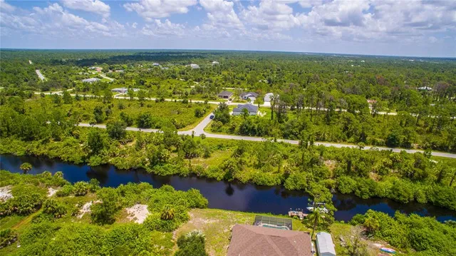 a view of a garden with an ocean and a building in the background