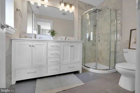 a bathroom with a double vanity sink toilet and shower