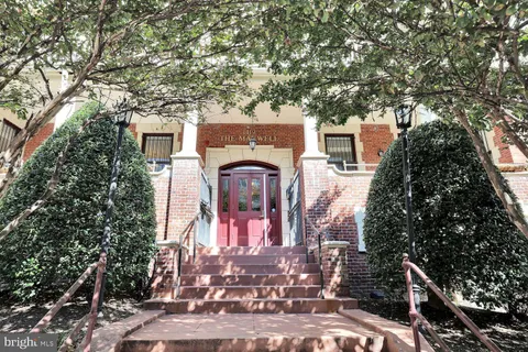 a front view of a house with a tree