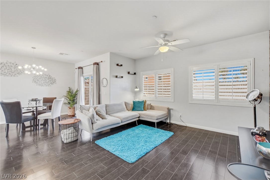 48 Jasmine Point Street Henderson, NV 89074 - Photo 18 of 62 Natural light illuminates this spacious living and dining area, featuring sleek dark flooring.