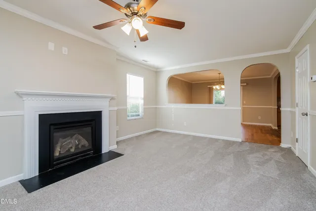 a view of an empty room with a fireplace and a window