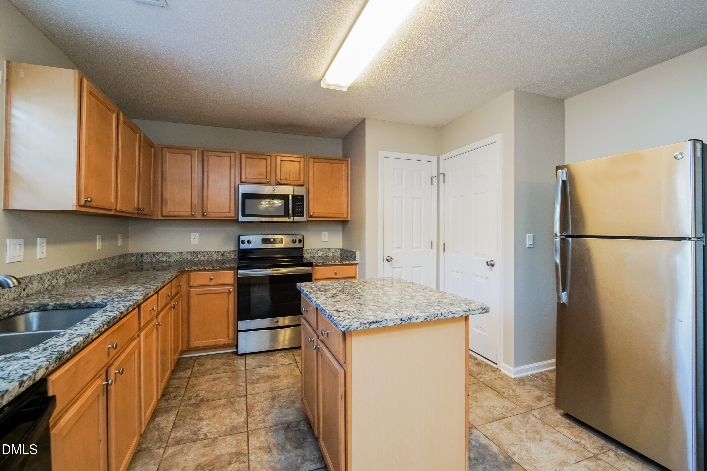 71 Brookhaven Drive Clayton, NC 27527 - Photo 6 of 17 a kitchen with granite countertop a refrigerator stove top oven and sink