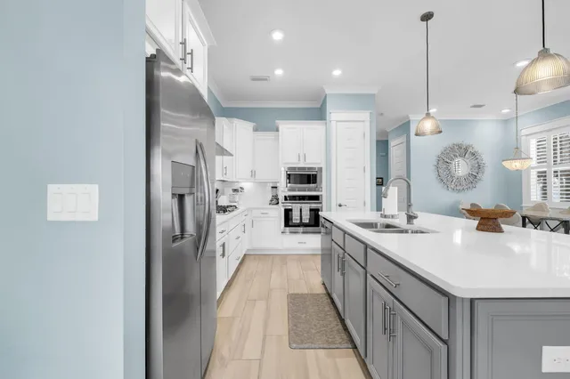 a living room with furniture kitchen view and a chandelier