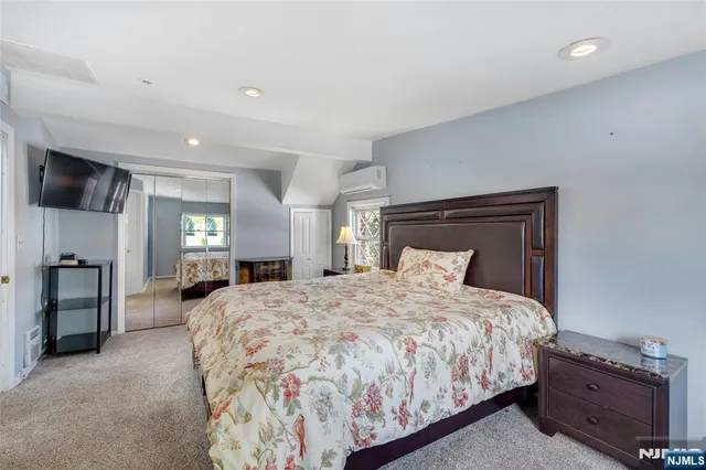 a spacious bedroom with a bed and a television