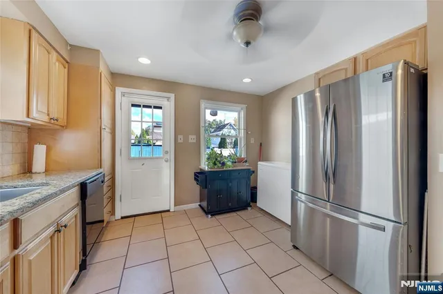 a kitchen with stainless steel appliances granite countertop a refrigerator and a sink