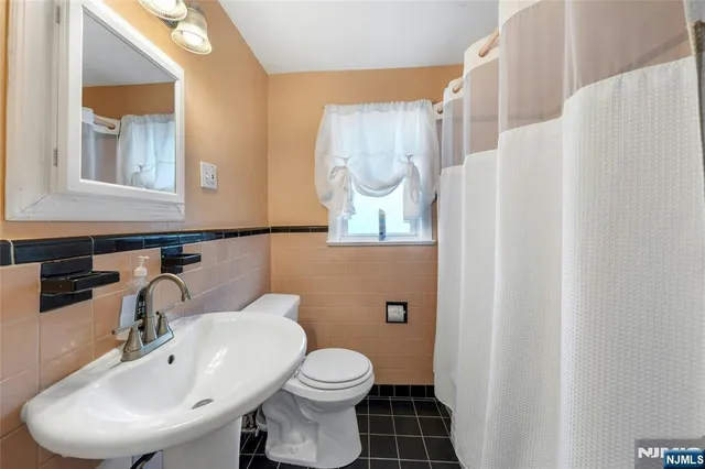 a bathroom with a sink mirror and toilet