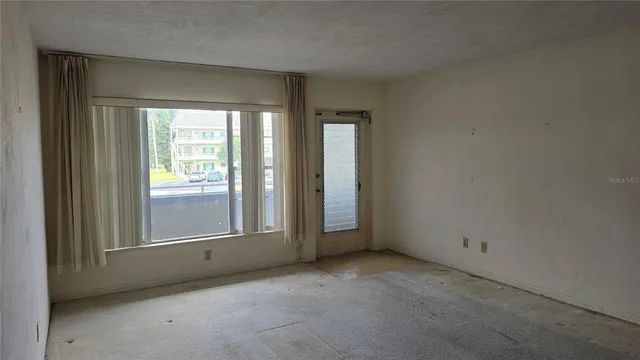 an empty room with windows and closet