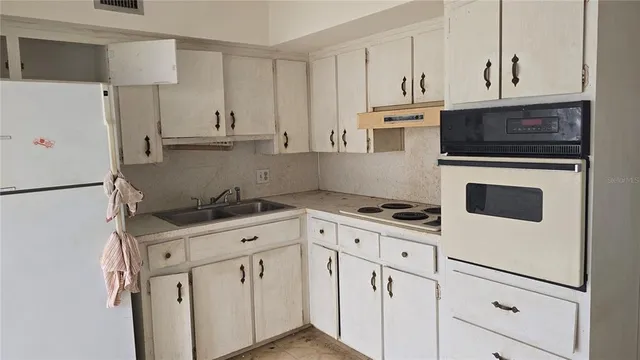 a kitchen with granite countertop white cabinets and white appliances