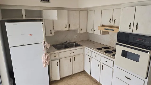 a kitchen with white cabinets and white appliances