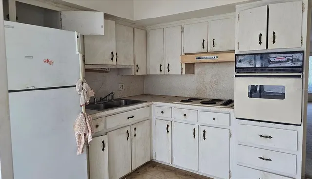 a kitchen with white cabinets and white appliances