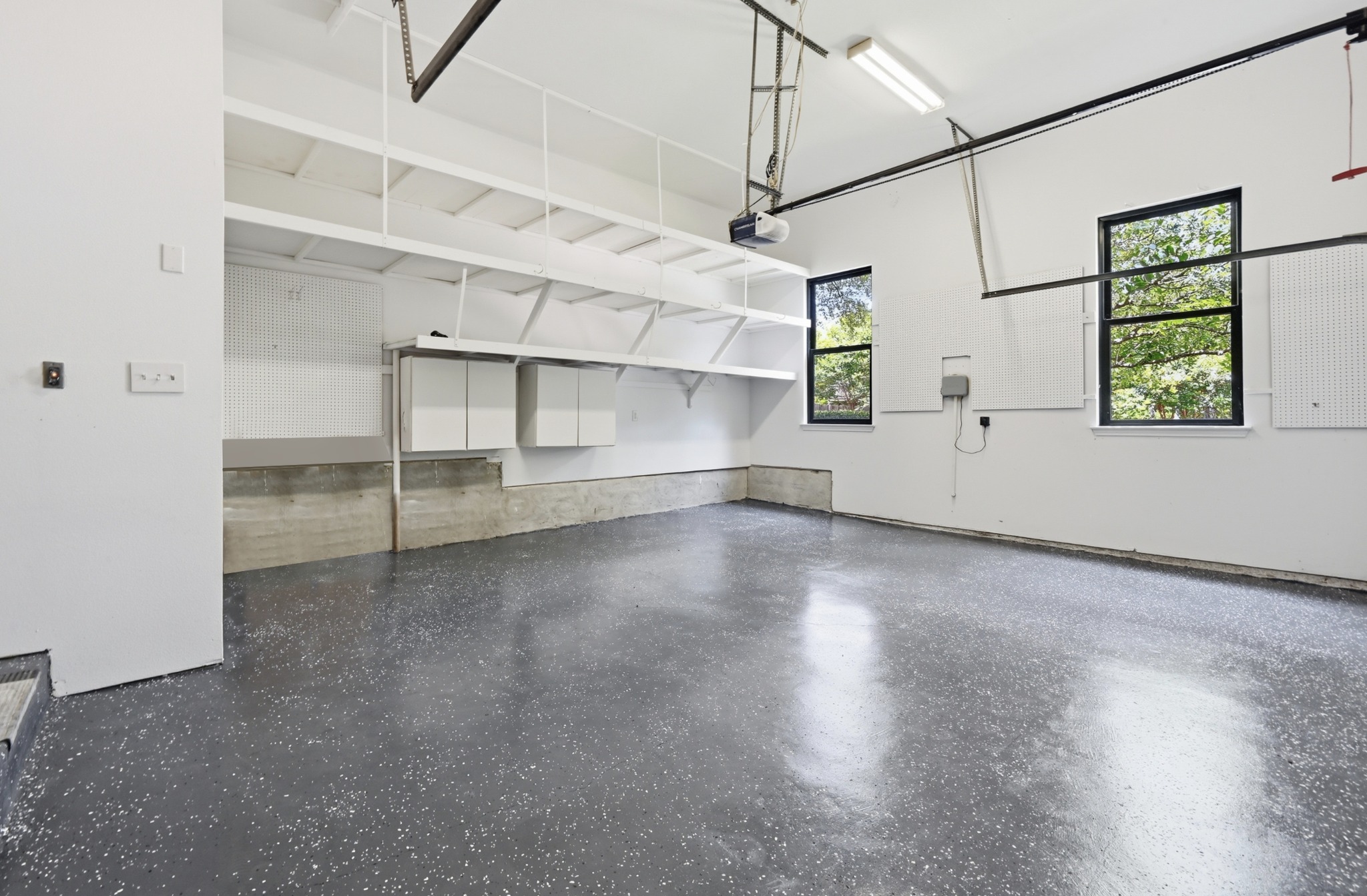 1107 Bowie Road Austin, TX 78733 - Photo 33 of 40 A well-organized garage space with ample shelving, storage cabinets, and a durable epoxy-coated floor.