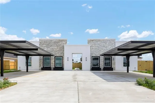 a view of a white house with a wooden fence