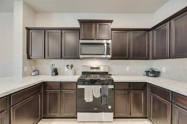 a kitchen with a sink stove and microwave