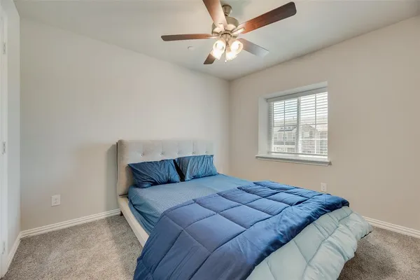 a bedroom with a large bed and a ceiling fan