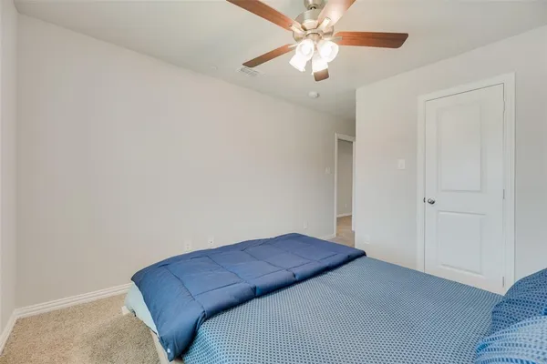 a living room with furniture and a chandelier fan