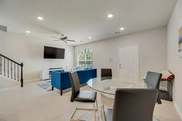 a living room with furniture a flat screen tv and a dining table