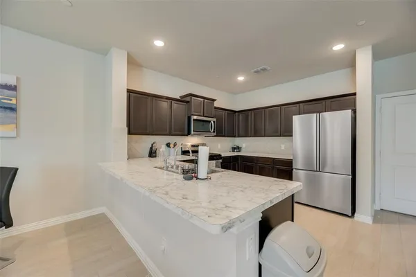a kitchen with stainless steel appliances granite countertop a sink refrigerator and microwave