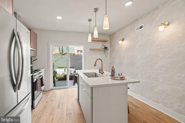 a kitchen with stainless steel appliances a sink stove and refrigerator