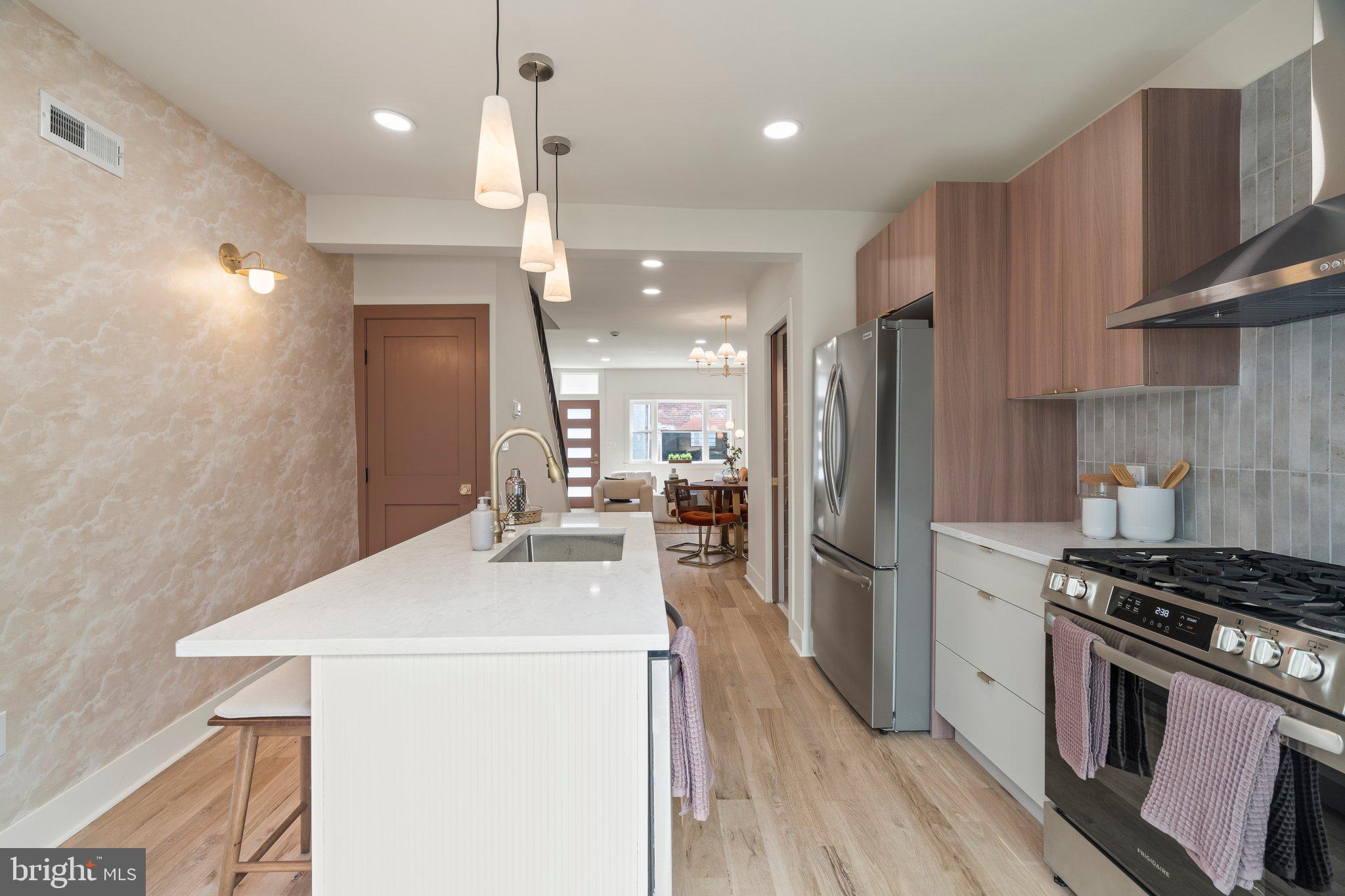 1031 Mercy Street Philadelphia, PA 19148 - Photo 16 of 34 a kitchen with a sink stainless steel appliances wooden floor and cabinets
