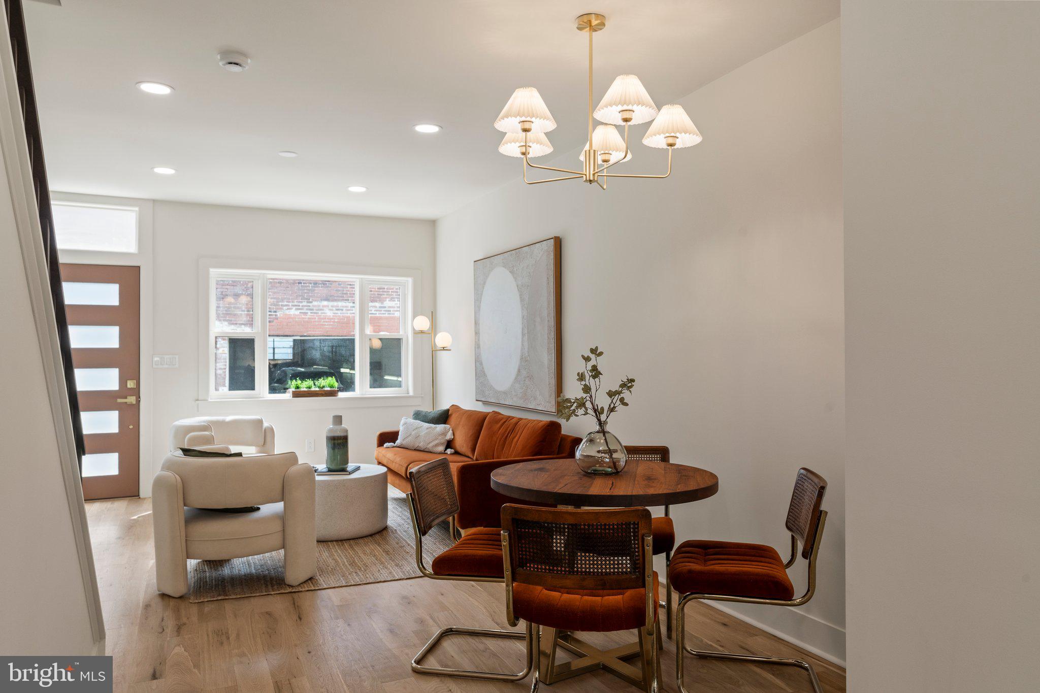 1031 Mercy Street Philadelphia, PA 19148 - Photo 6 of 34 a dining room with wooden floor a chandelier a glass table and chairs