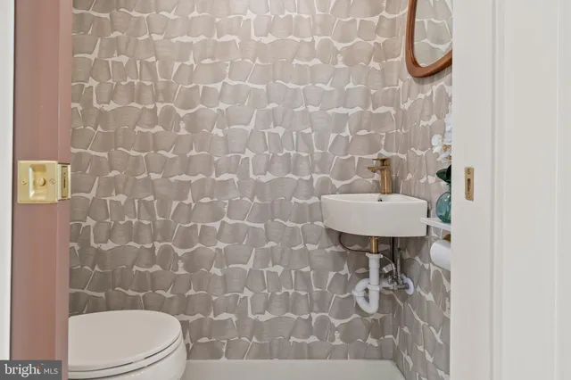 a bathroom with a sink toilet and a mirror