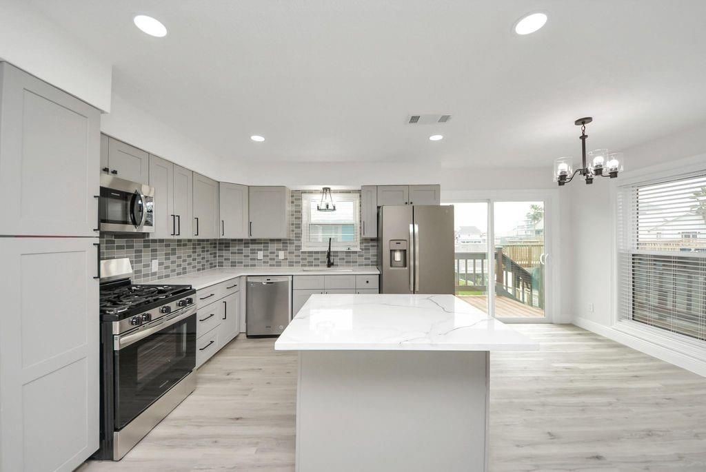 485 Pompano Street Bayou Vista, TX 77563 - Photo 14 of 32 a large kitchen with stainless steel appliances kitchen island a sink stove and refrigerator