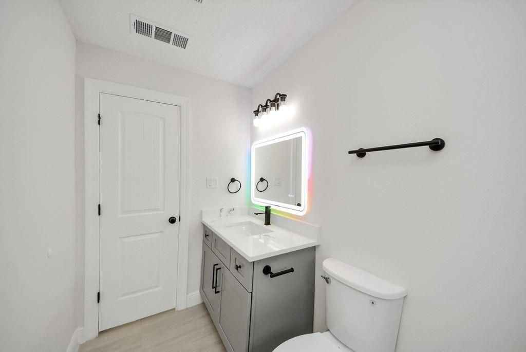 485 Pompano Street Bayou Vista, TX 77563 - Photo 18 of 32 a bathroom with a granite countertop sink mirror and toilet