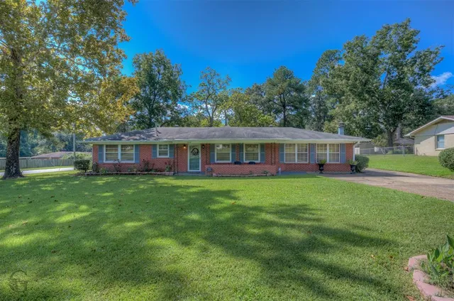 a view of a house with a yard table and chairs
